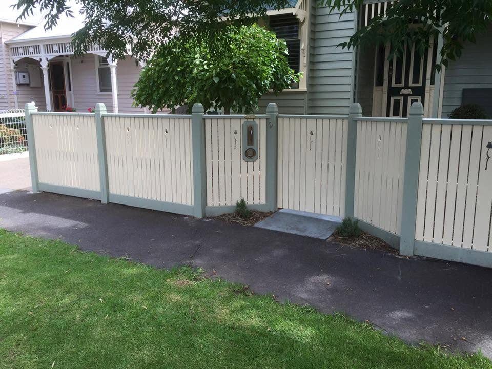 Painted heritage picket fence with sage green posts on a weatherboard home