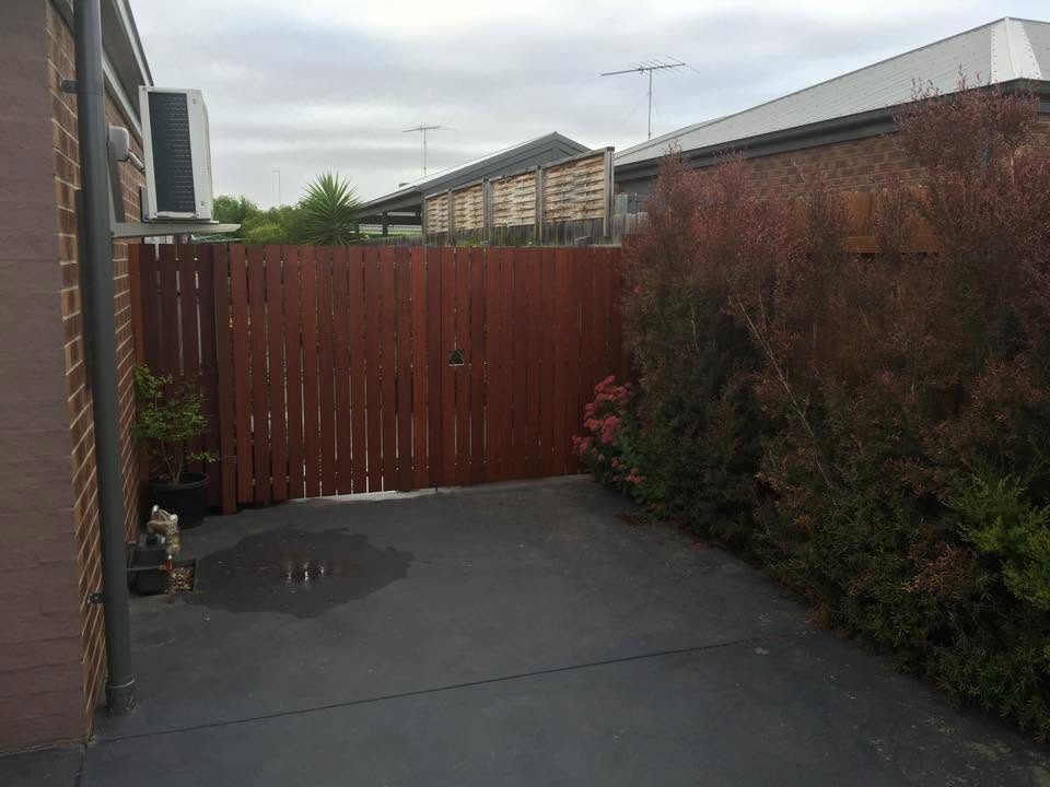 Merbau timber double gate closing off a driveway between two homes