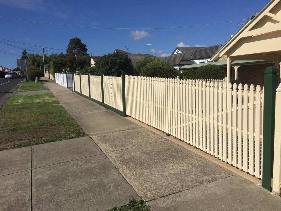 Cream picket fence with green posts running along a Geelong footpath