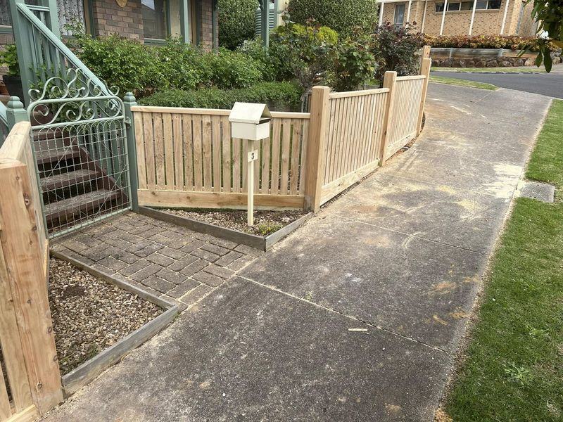 Natural timber pickets meeting an original heritage gate