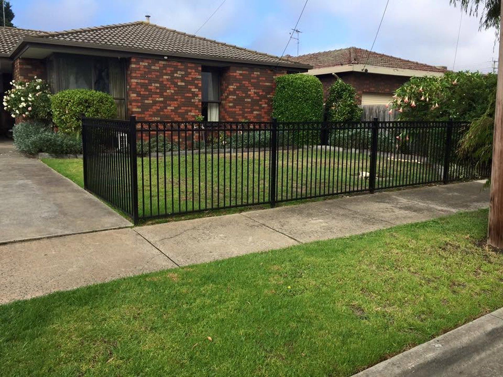 Black powder coated aluminium front fence along a Geelong brick home