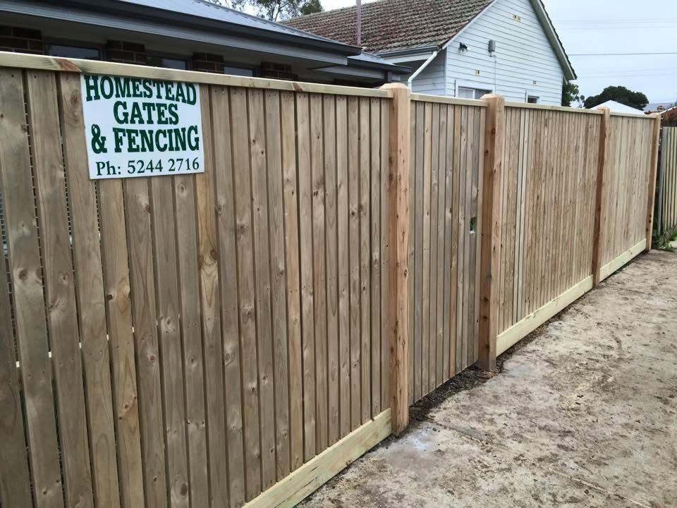 A finished Homestead paling fence with the company sign fixed to it