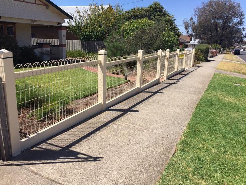 Cream posts and woven wire panels along a front garden